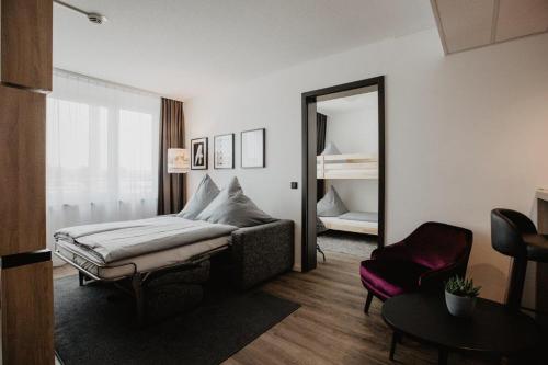 a bedroom with a bed and a mirror and a chair at Arivo Forchheim in Forchheim