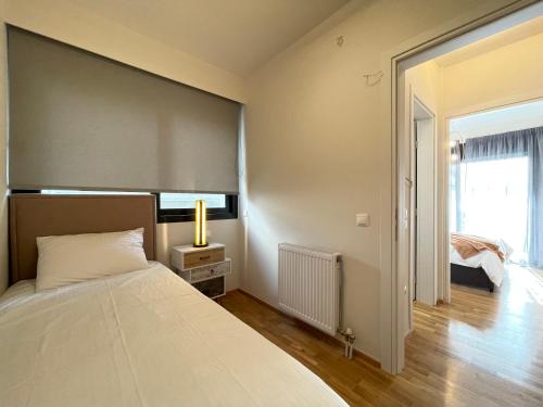 a bedroom with a large white bed and a window at Athenean Modern Escape near Marina Flisvos in Athens
