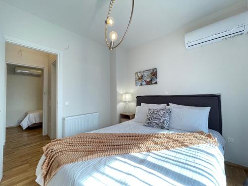 a bedroom with a large bed with white walls at Athenean Modern Escape near Marina Flisvos in Athens