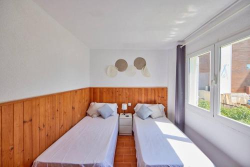 2 letti in una camera con 2 finestre di Nura Houses Apartment Magaluf 2 a Magaluf