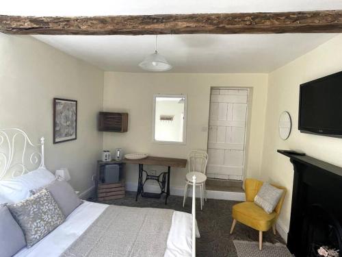 a bedroom with a bed and a desk and a television at Y Felin Bed and Breakfast and Smallholding in Caersws