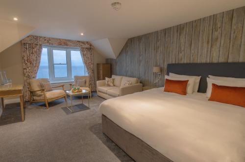 a bedroom with a large bed and a living room at The Brudenell in Aldeburgh