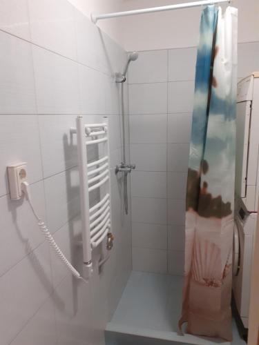 a bathroom with a shower with a phone on the wall at Jókai Apartman Békéscsaba in Békéscsaba