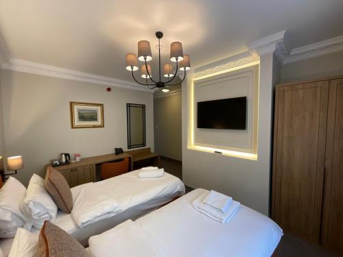 a hotel room with two beds and a flat screen tv at Old Mill Hotel & Lodge in Bath