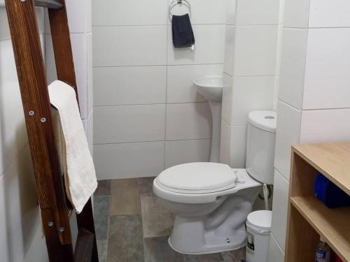 a white bathroom with a toilet and a sink at Acogedora y Céntrica Casa de Huéspedes in Coquimbo