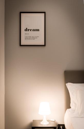 a picture on a wall above a bed with a lamp at TURINHOMETOWN Residence Apartments in Turin