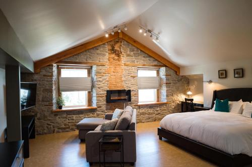 a bedroom with a large bed and a stone wall at Kemptville Suites in Kemptville