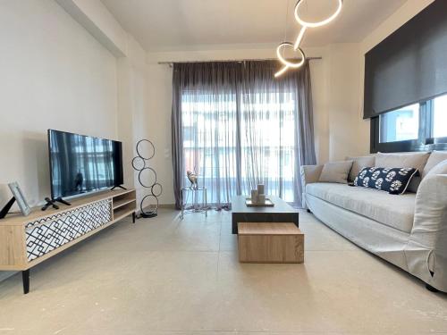 a living room with a couch and a flat screen tv at Athenean Modern Escape near Marina Flisvos in Athens