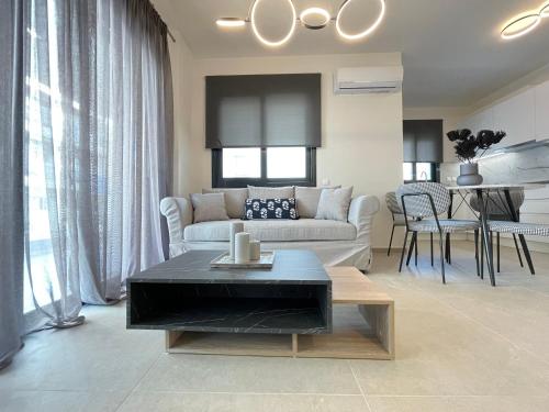 a living room with a couch and a table at Athenean Modern Escape near Marina Flisvos in Athens