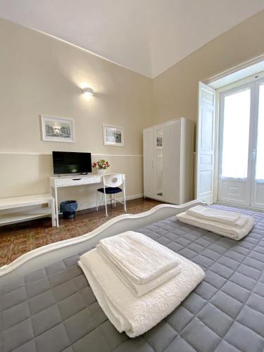 a bedroom with a bed and a desk with a computer at Duomo Rooms b&b in Lentini