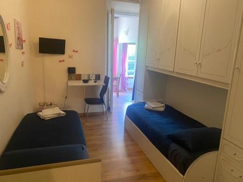 Habitación pequeña con 2 camas y escritorio. en Villa Zara, en Siena