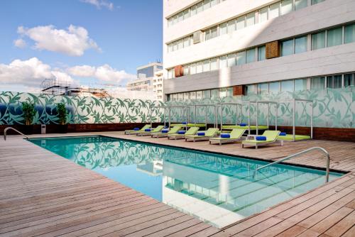 a swimming pool with lounge chairs next to a building at VIP Grand Lisboa Hotel & Spa in Lisbon