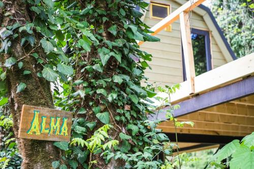 a sign on a tree in front of a house at Duende Hotel in Lagodekhi