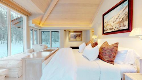 a bedroom with a large white bed and a table at Trails Edge by Snowmass Vacations in Aspen