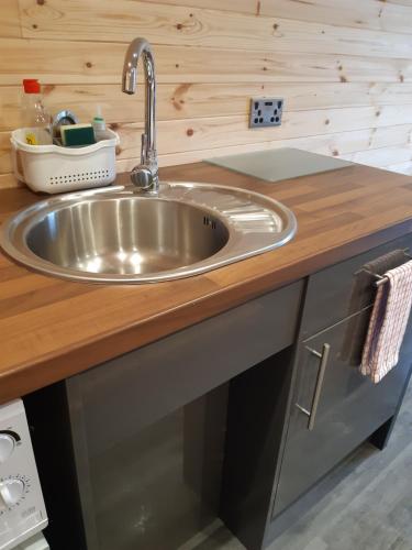a kitchen counter with a stainless steel sink at Loch Caroy Pods in Ose
