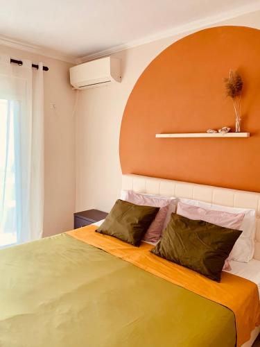 a bedroom with a large bed with an orange headboard at Family Tree - WATER Available - SELF check in in Golem