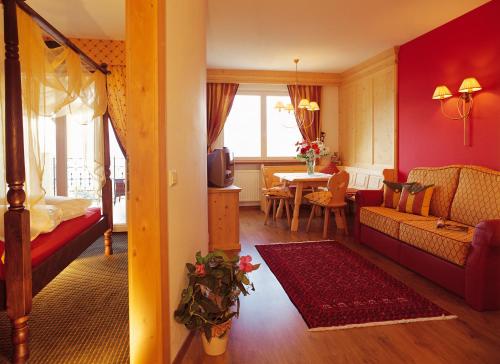 a living room with a couch and a table at Hotel Finkennest - Panoramic Garden Resort in Schenna