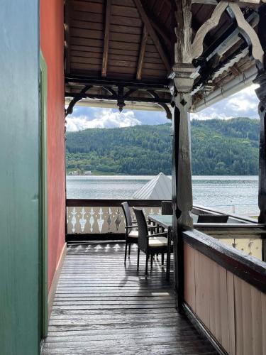a porch with chairs and a table and a view of the water at Villa Streintz in Millstatt