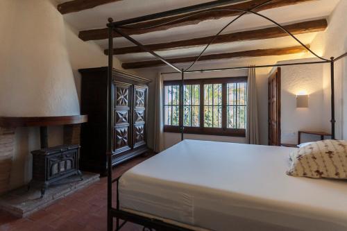 a bedroom with a bed and a fireplace at Let's Holidays 7 Xemeneies house in Tossa de Mar