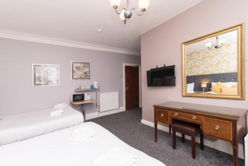 1 dormitorio con cama, escritorio y espejo en The Linden Leaf Rooms - Classy & Stylish, en Nottingham