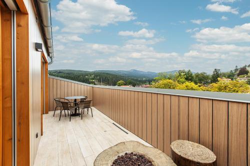 a balcony with a table and chairs and a view at Javor apartmán na Šumavě in Železná Ruda