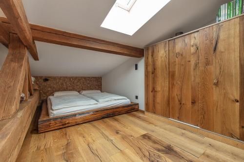 a bedroom with a bed in a room with wooden walls at Javor apartmán na Šumavě in Železná Ruda