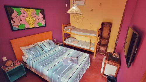 a bedroom with a bed and bunk beds in it at Farofa Loca Hostel in Morro de São Paulo