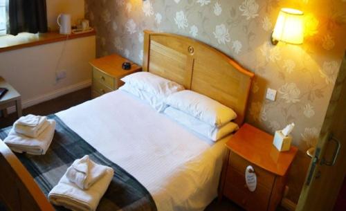 a bedroom with a bed with white sheets and pillows at Ban-Car Hotel in Cairness