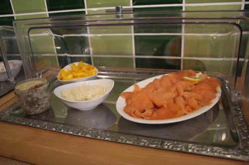 a tray with a plate of food and bowls of food at Hotel Miriquidi All Inklusive in Kurort Oberwiesenthal