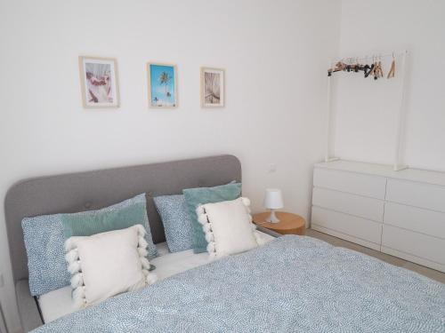 1 dormitorio con 1 cama con almohadas azules y blancas en Apartment La Mer with Pool en Lido di Jesolo