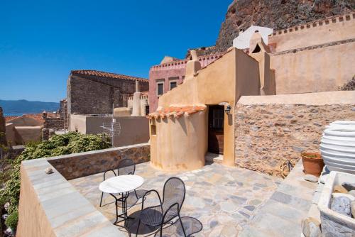 a patio with chairs and a table on a building at Goulas Traditional Guesthouse in Monemvasia