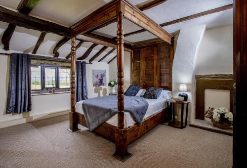 a bedroom with a canopy bed and a window at Finest Retreats - Ellen's Cottage in Bury