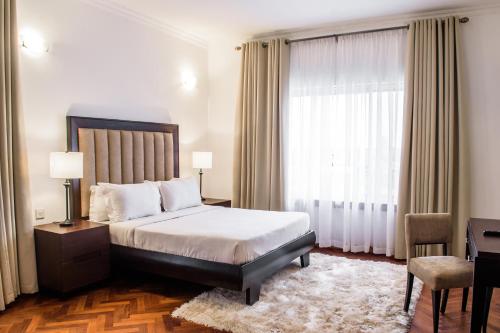 a bedroom with a bed and a desk and a window at Pier Harbour Residences and Spa in Lagos