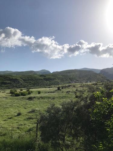 Un campo verde con montañas al fondo en Kasaj Villa, en Gjirokastra