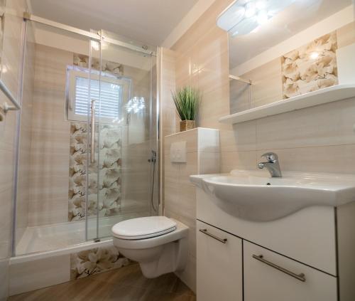 a bathroom with a toilet and a sink and a shower at Apartments Bene in Rab