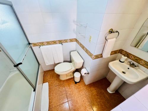 a small bathroom with a toilet and a sink at Suite Colonial by Cristi in Santo Domingo