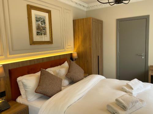 a bedroom with a bed with white sheets and pillows at Old Mill Hotel & Lodge in Bath