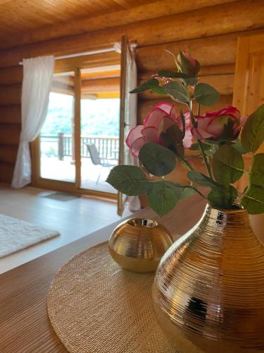 a vase with flowers in it sitting on a table at Traumhaftes Blockhaus am Rhein in Kamp-Bornhofen