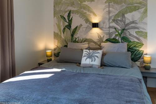 a bedroom with a bed with a tropical wallpaper at Les Gîtes du Griffon l'Erable in Aubigny-lès-Sombernon