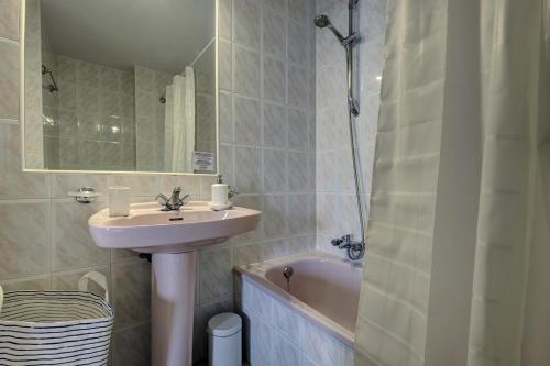 een badkamer met een wastafel en een bad bij 053 - Two Bed Mijas Golf Apartment in popular Matchroom Golf Club in Fuengirola