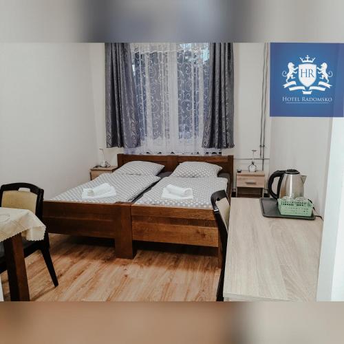 a bedroom with a bed and a table and a window at HOTEL RADOMSKO in Radomsko