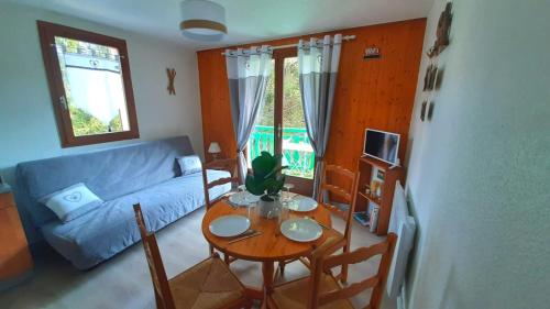 a living room with a table and a blue couch at Escapade Au Calme De La Rivière in Métabief