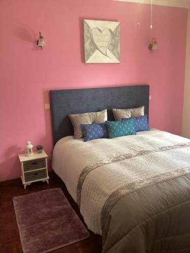 a bedroom with a bed and a pink wall at Arouca à Varanda in Arouca