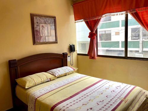 1 cama en un dormitorio con ventana y 1 cama sidx sidx sidx sidx en Hostal Montesa, en Guayaquil