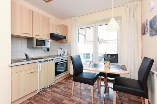 カロリーネンジールにあるFerienwohnung Oberdeckのキッチン(テーブル、椅子付)、窓付きのキッチン