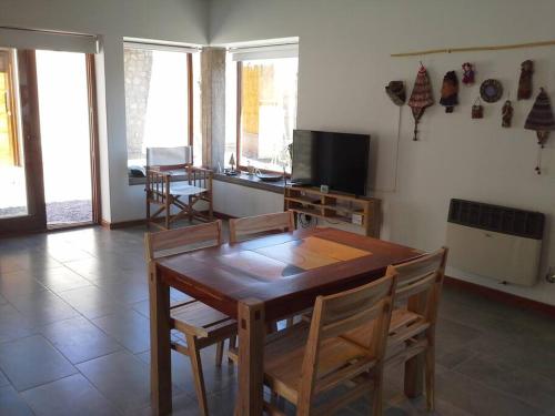 a dining room with a wooden table and chairs at LA FLORITA in Tilcara