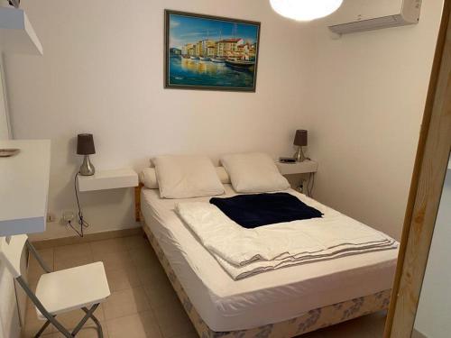 a bed in a room with a picture on the wall at Bel Appartement avec Jardin pour 4 Personnes Climatisé avec Accès plage de la Gorguette à pied in Sanary-sur-Mer