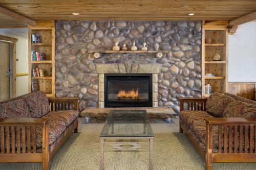 a living room with a stone wall with a fireplace at River Canyon Lodge in Moab