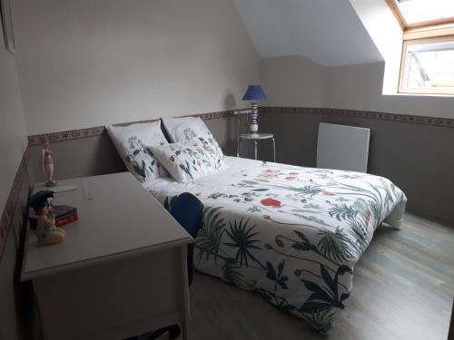 een kleine slaapkamer met een bed en een tafel bij macareux in Binic