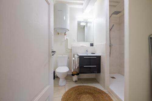 une salle de bain blanche avec un lavabo et des toilettes dans l'établissement HONORÊ SUITE SAINT PAUL, à Lyon